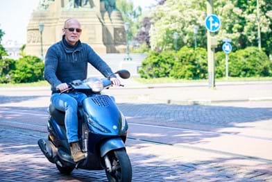 Ron Staallekker op zijn scooter in Den Haag.